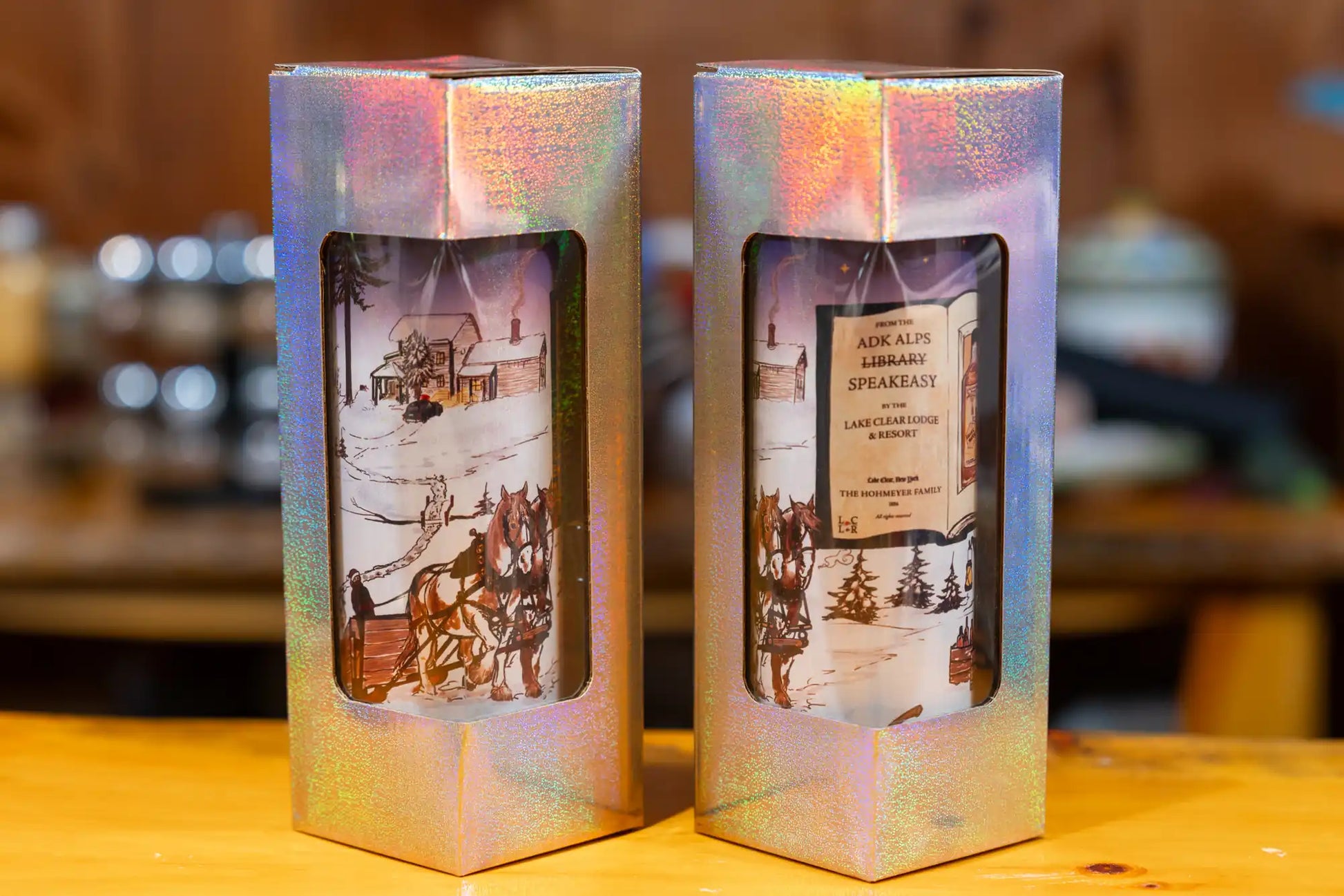 Two holographic shimmer gift boxes with Lake Clear Lodge tumblers.